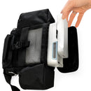 Hand placing portable oxygen concentrator into black mesh backpack compartment
