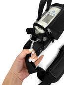 Hand holding strap of black backpack with Inogen One G4 portable oxygen concentrator