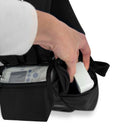 Hand placing battery pack into black Inogen One G4 backpack side pocket