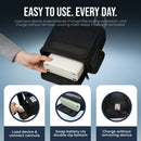 Hand placing portable oxygen concentrator in black carry bag with easy access zippers and charging.