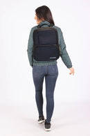 Woman wearing a black CPAP backpack for portable oxygen concentrator, shown from behind.