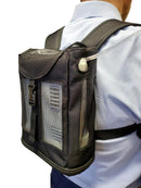 Black mesh portable oxygen concentrator backpack with shoulder straps, worn by person