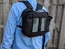 Black Inogen One G3 backpack with mesh panels worn on back, outdoor setting
